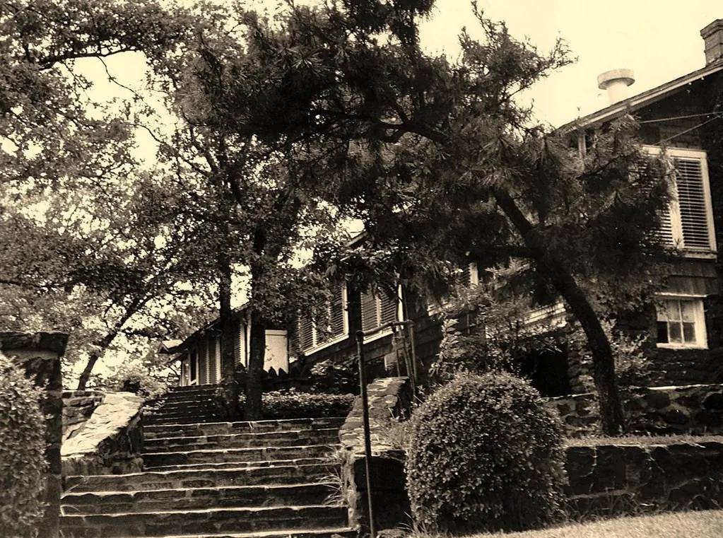 Stone steps up to a shingled house under the trees at Top O’ Hill Terrace